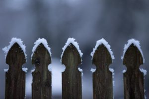 A wooden fence is covered in snow